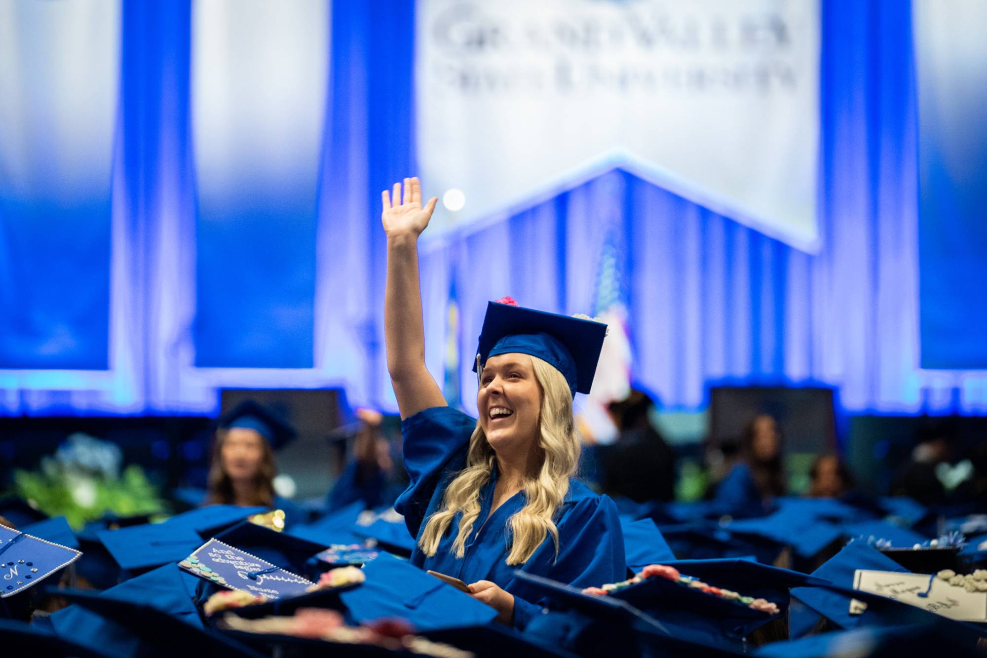 A grad raises her hand at commencement